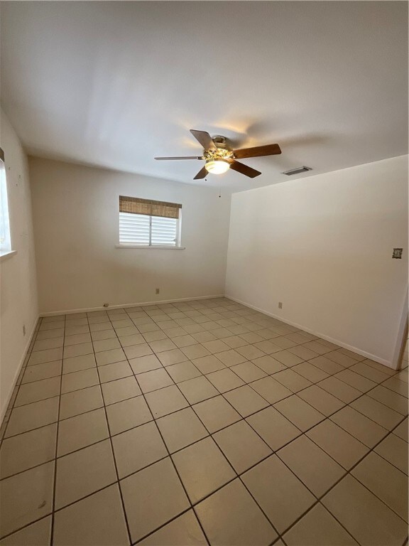 spare room featuring light tile patterned floors and ceiling fan