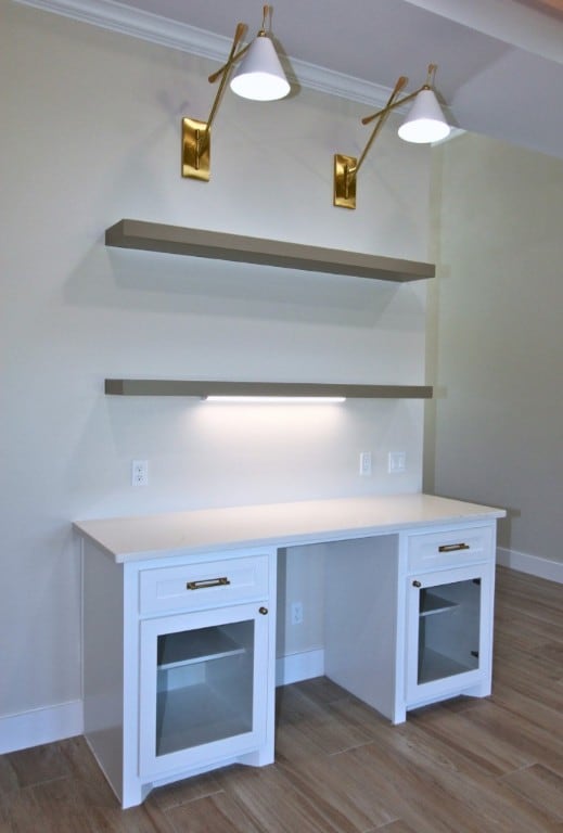 kitchen featuring dark wood-type flooring, pendant lighting, crown molding, and white cabinets