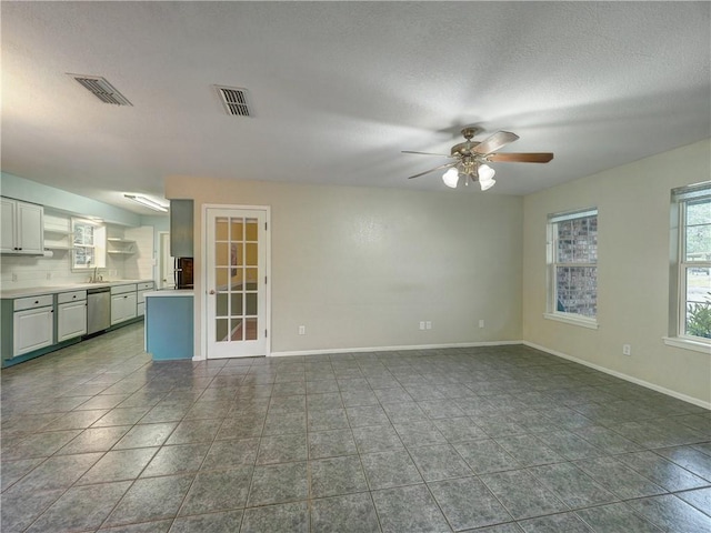 1305 S Whitney St, Aransas Pass, TX 78336 - spare room with ceiling fan, a sink, a textured ceiling, baseboards, and dark tile patterned flooring