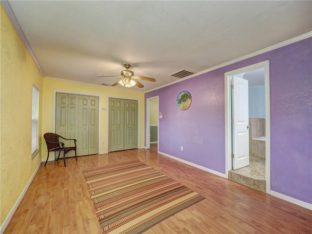 1305 S Whitney St, Aransas Pass, TX 78336 - bedroom featuring wood finished floors, ornamental molding, multiple closets, baseboards, and ensuite bathroom