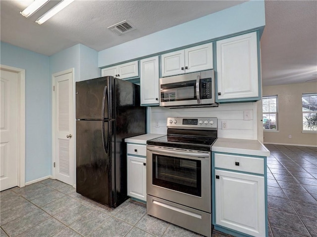 1305 S Whitney St, Aransas Pass, TX 78336 - kitchen with stainless steel appliances, light countertops, light tile patterned flooring, and a textured ceiling