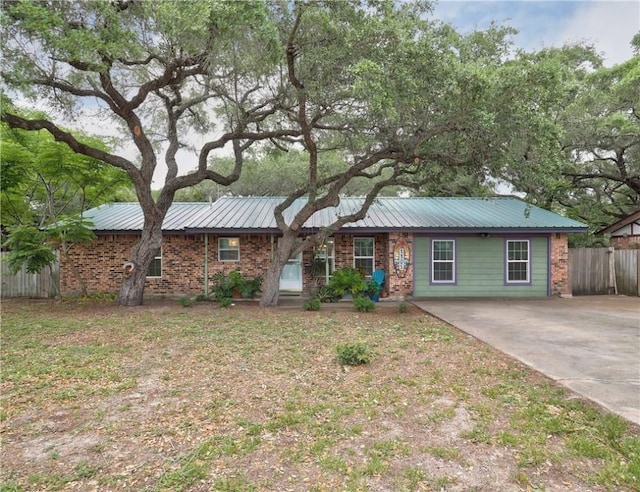 1305 S Whitney St, Aransas Pass, TX 78336 - ranch-style home featuring fence, metal roof, and brick siding