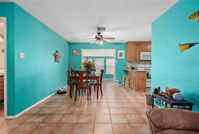 dining space with light tile patterned floors and ceiling fan