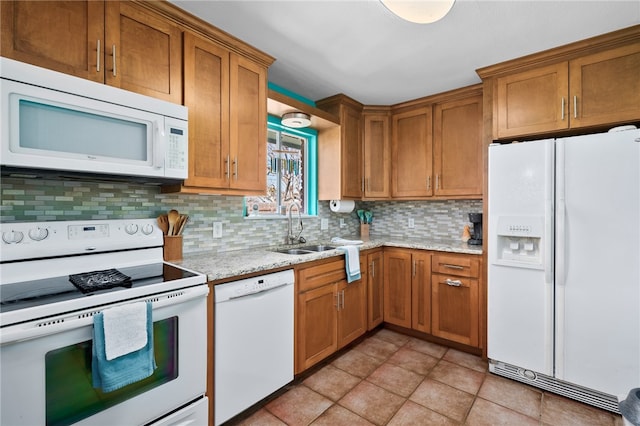 kitchen with light stone countertops, sink, tasteful backsplash, white appliances, and light tile patterned floors