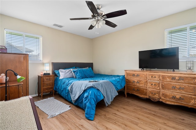 bedroom featuring multiple windows, ceiling fan, and light wood-type flooring