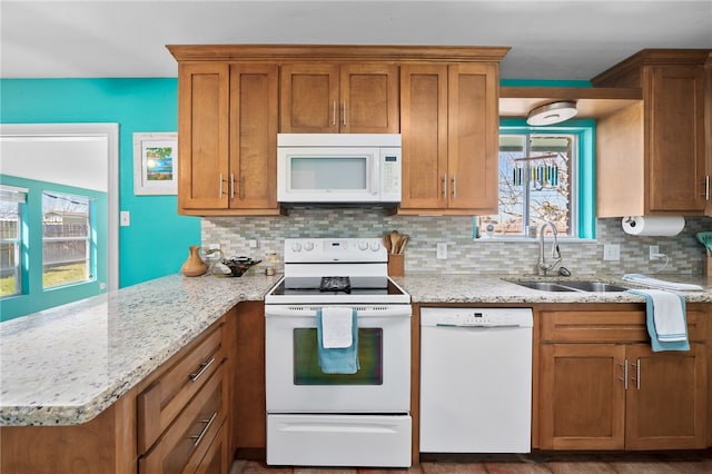 kitchen with plenty of natural light, tasteful backsplash, sink, and white appliances