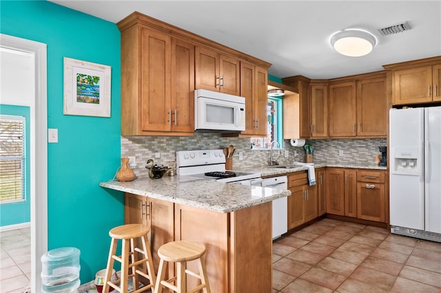 kitchen with a healthy amount of sunlight, white appliances, and backsplash