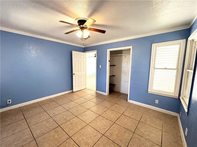 unfurnished bedroom with a ceiling fan, crown molding, baseboards, and a textured ceiling