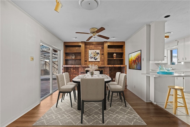 dining room with ornamental molding, built in features, hardwood / wood-style flooring, and ceiling fan