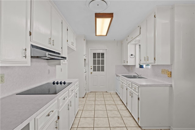 kitchen featuring white cabinets, sink, light tile patterned floors, and black electric stovetop