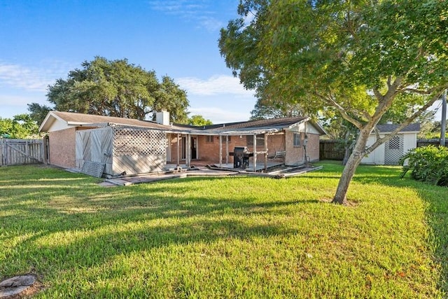 rear view of property featuring a lawn and a patio