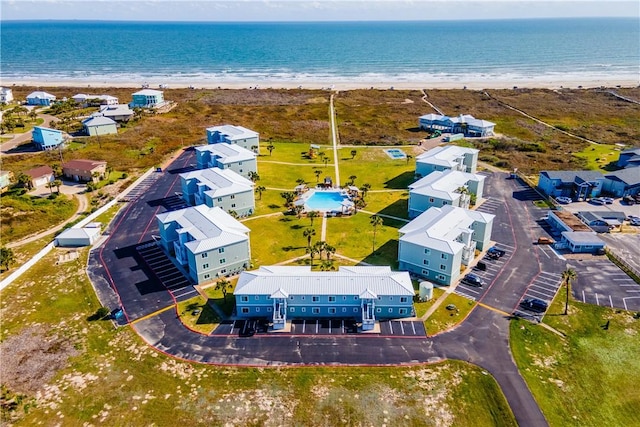 birds eye view of property with a water view and a beach view