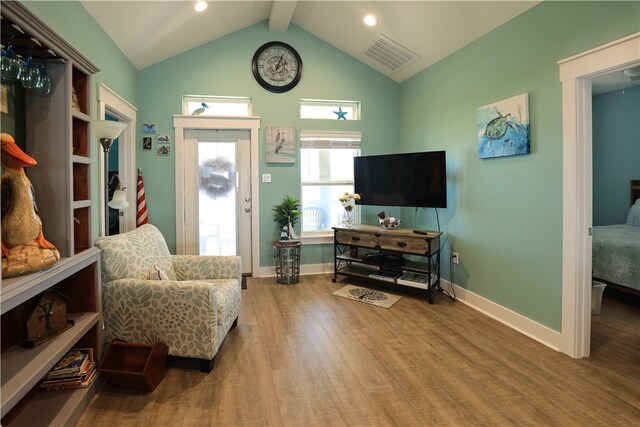 sitting room with lofted ceiling with beams and wood-type flooring