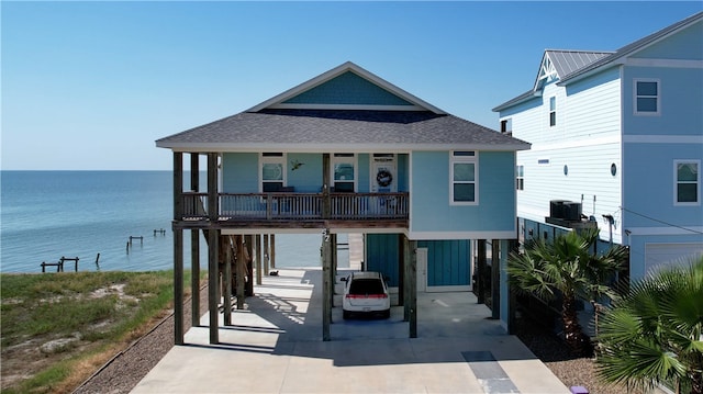 view of front of house with a carport, a water view, and a porch