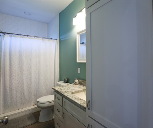 bathroom with toilet, vanity, and a shower with shower curtain