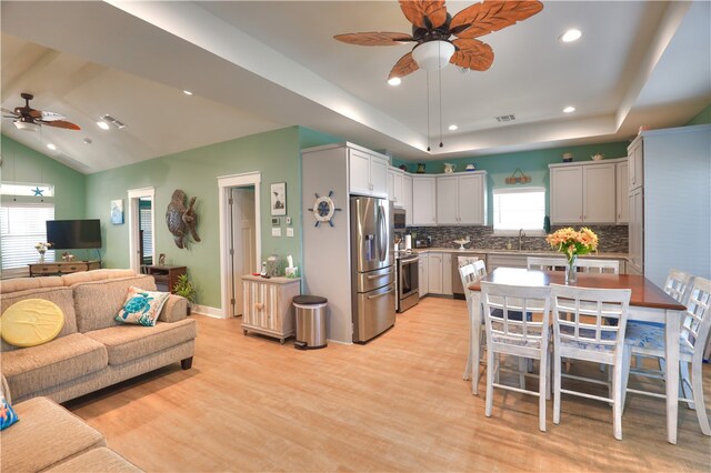 kitchen with a wealth of natural light, appliances with stainless steel finishes, ceiling fan, and a center island