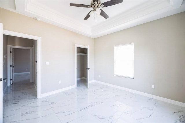 unfurnished bedroom featuring a raised ceiling, crown molding, ceiling fan, and a closet