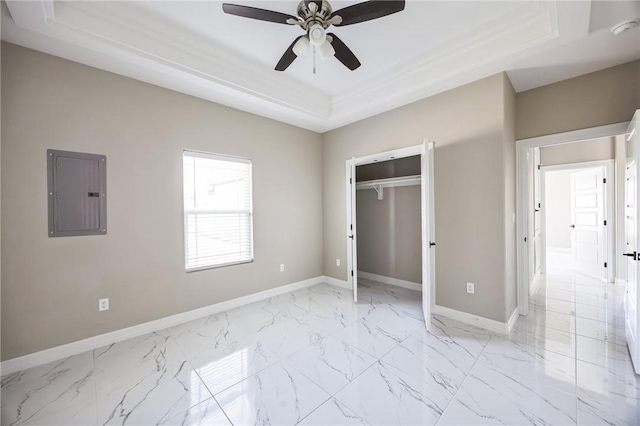 unfurnished bedroom with a closet, electric panel, a raised ceiling, and ceiling fan