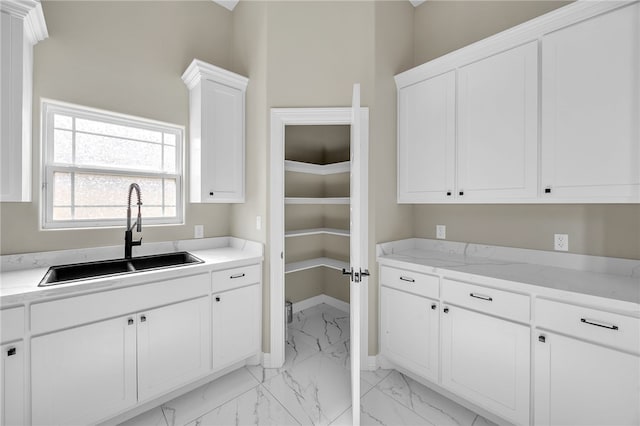 kitchen featuring white cabinetry and sink