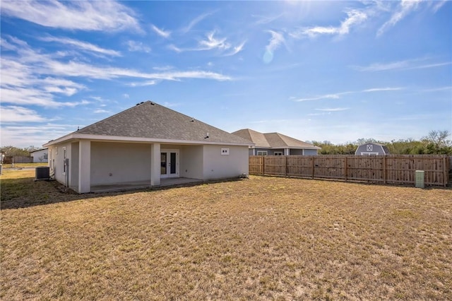 back of house with a yard and central AC