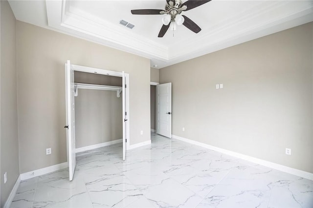 unfurnished bedroom featuring ceiling fan, ornamental molding, a raised ceiling, and a closet