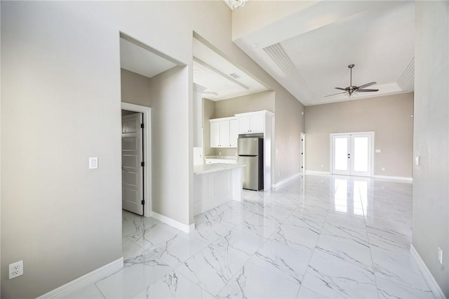 interior space featuring ornamental molding, a raised ceiling, ceiling fan, and french doors