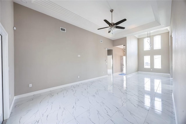 spare room with crown molding, ceiling fan, and a raised ceiling