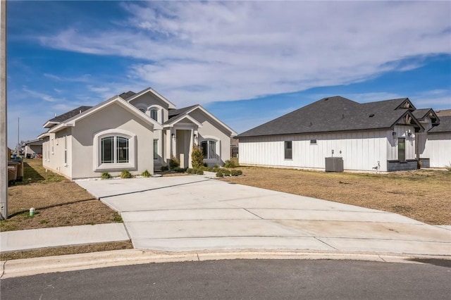 view of front of home with central AC unit and a front lawn