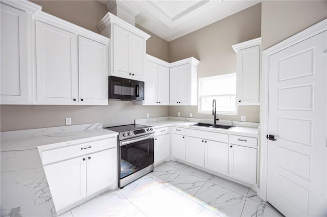 kitchen with white cabinetry, light stone counters, sink, and stainless steel range with electric cooktop