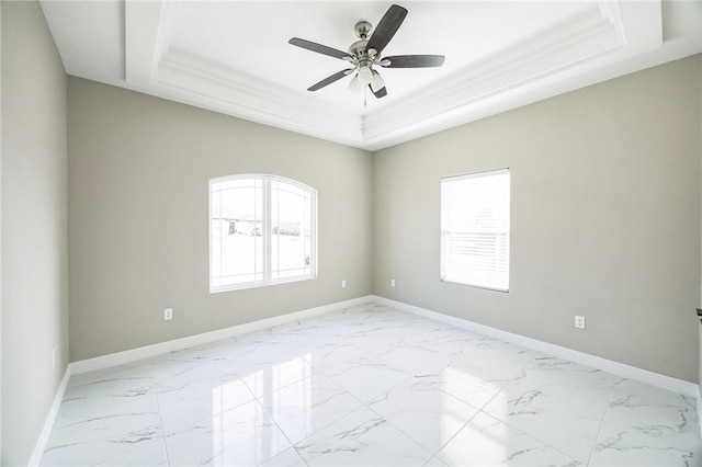 unfurnished room with a raised ceiling, ornamental molding, and ceiling fan