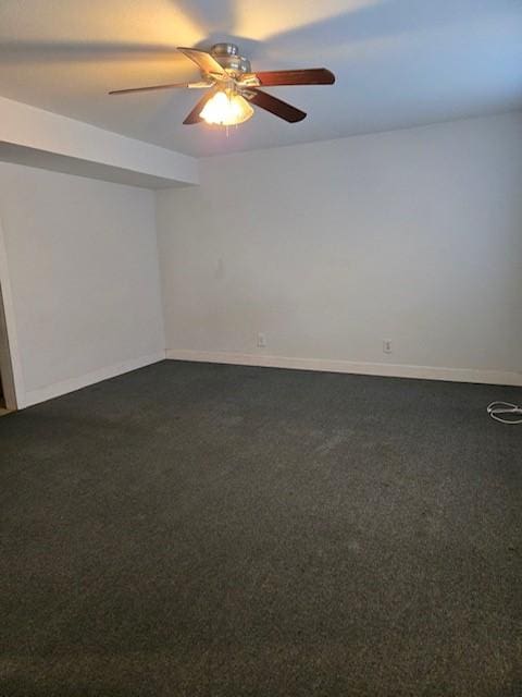 spare room featuring ceiling fan and dark colored carpet