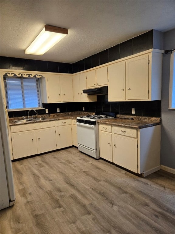 kitchen featuring white cabinets, white appliances, sink, and light hardwood / wood-style flooring