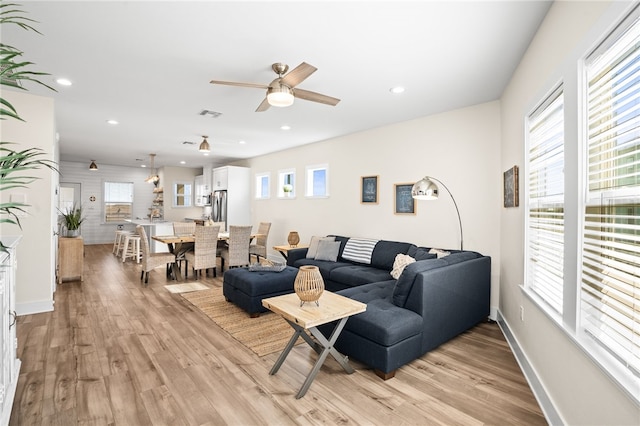 living room with light wood-type flooring and ceiling fan