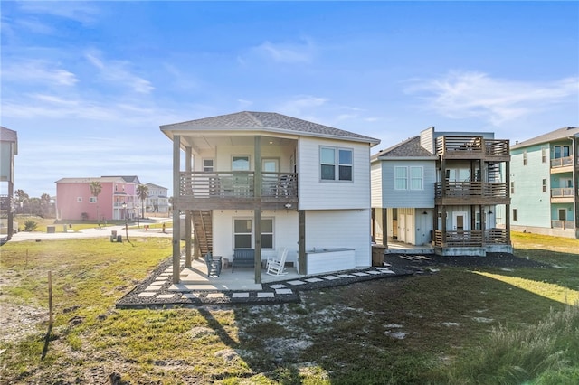 rear view of house featuring a yard, a patio area, and a balcony