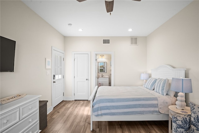 bedroom featuring wood-type flooring, ensuite bathroom, and ceiling fan