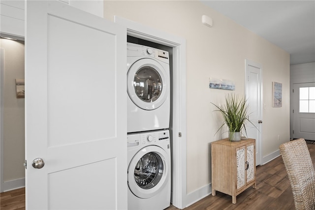 laundry area with dark hardwood / wood-style flooring and stacked washer / drying machine