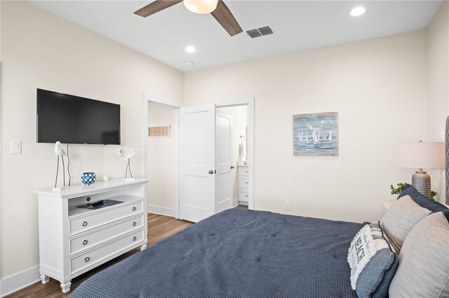 bedroom featuring dark hardwood / wood-style flooring, ceiling fan, and connected bathroom