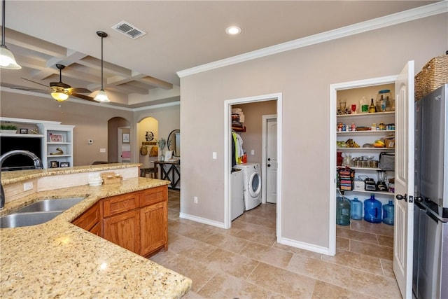 7205 Lake Serenity Dr, Corpus Christi, TX 78414 - kitchen featuring washing machine and dryer, a sink, freestanding refrigerator, a ceiling fan, and arched walkways