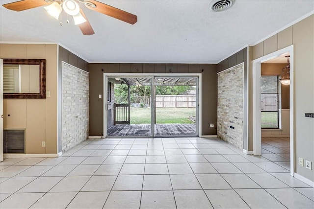 tiled spare room with a textured ceiling, ceiling fan, and ornamental molding