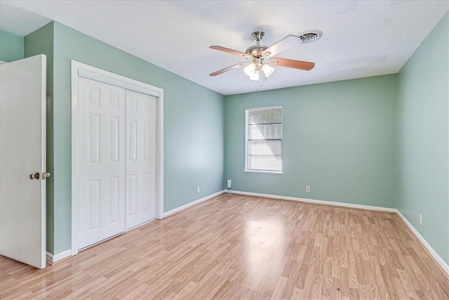 unfurnished bedroom with a closet, light hardwood / wood-style flooring, and ceiling fan