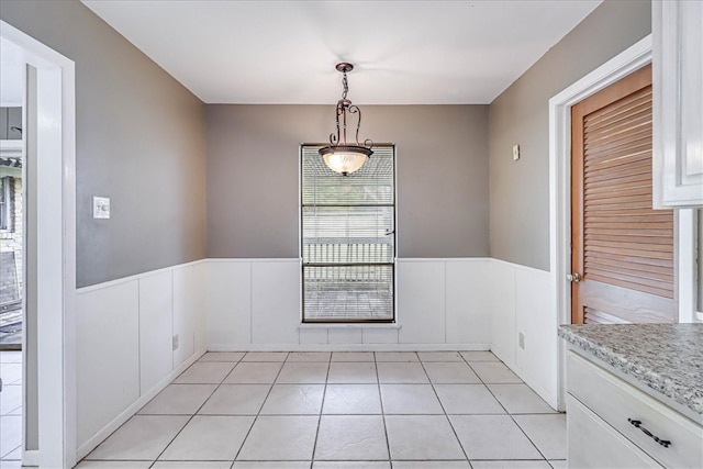 unfurnished dining area with light tile patterned flooring