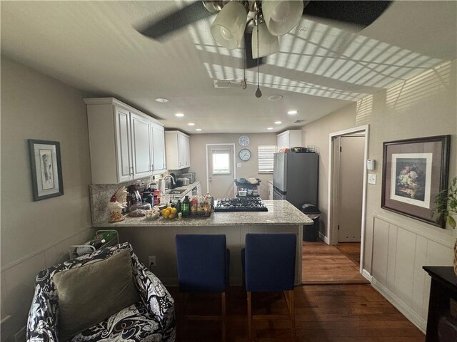 1210 Brentwood Dr, Corpus Christi, TX 78404 - kitchen with dark wood-style flooring, gas stovetop, a sink, white cabinets, and a peninsula