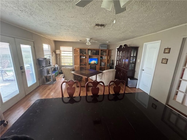 1210 Brentwood Dr, Corpus Christi, TX 78404 - dining room featuring french doors, a ceiling fan, a textured ceiling, visible vents, and wood finished floors