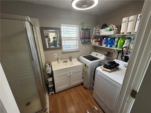 1210 Brentwood Dr, Corpus Christi, TX 78404 - laundry room with a textured ceiling, independent washer and dryer, wood finished floors, and cabinet space