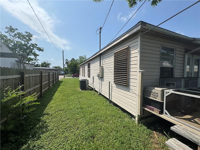 1210 Brentwood Dr, Corpus Christi, TX 78404 - view of side of home featuring a lawn, central AC unit, and fence