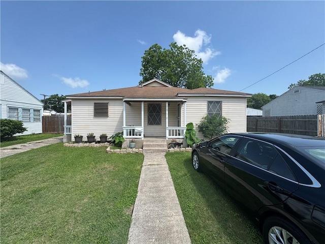 1210 Brentwood Dr, Corpus Christi, TX 78404 - bungalow-style house with fence, roof with shingles, covered porch, and a front lawn