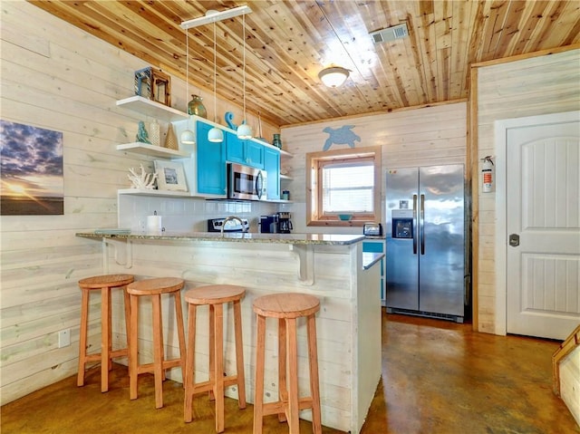 kitchen featuring appliances with stainless steel finishes, a kitchen bar, and kitchen peninsula