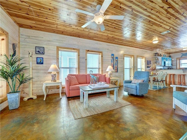 living room with ceiling fan, concrete floors, and wood ceiling