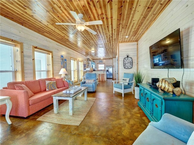 living room with ceiling fan, wood ceiling, and wood walls