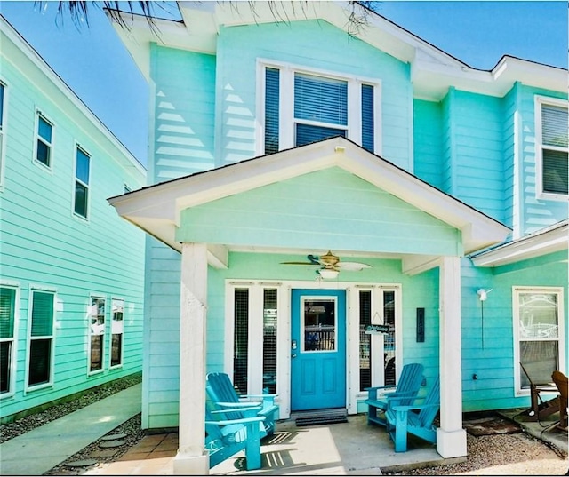 entrance to property featuring ceiling fan and covered porch